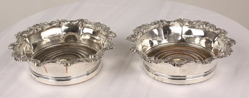 A pair of very lovely antique, period Georgian, hallmarked silver-rimmed wine coasters, rims are solid silver and are extremely decorative. Made by the English silversmith Michael Bolton, circa 1800. The bowls of the coastors are Sheffield plate