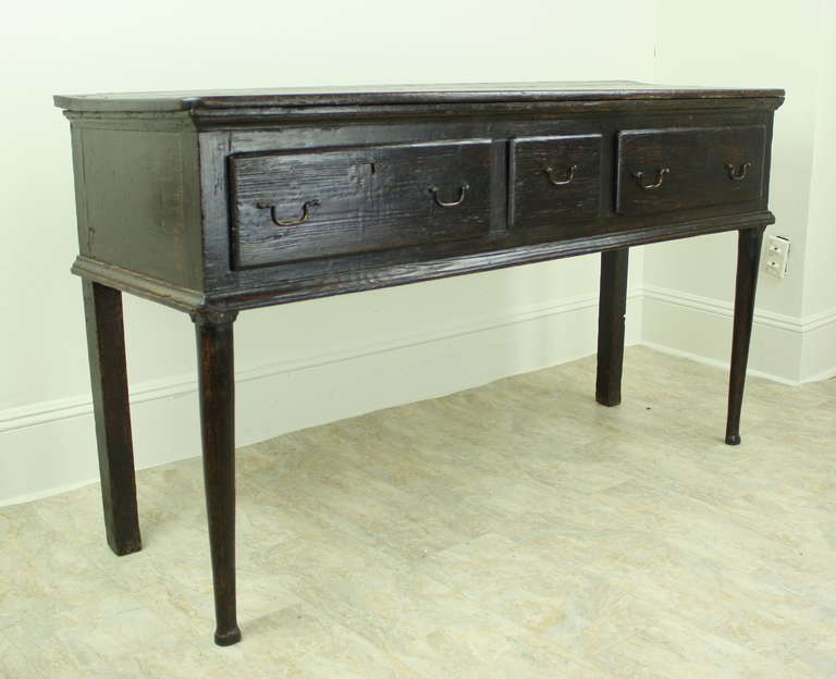 A rich dark oak credenza offering all the classic very early components of the period.  Great size for a variety of places in the home, in keeping with the farm table look.  This excellent console  would be lovely in an entry hall, setting the tone