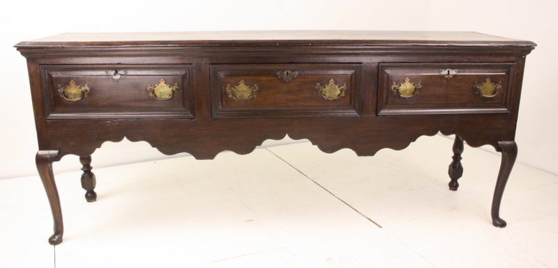 A long and elegant County console table, dramatic and very impressive. Cabriole legs end in a pad foot in the front, while the back legs are strongly carved, boldly shaped, supports. Grain and patina are lovely, and the carving on panels of the