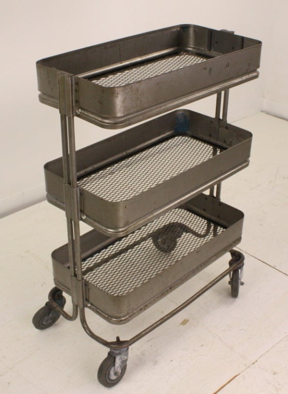 From an old French textile mill, a charming rolling cart.  Three tiers of perforated steel provide storage, and the piece offers a charming look.