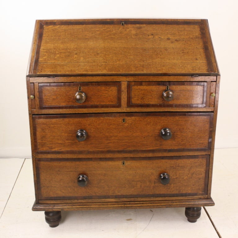 This slanty-top chest is a good example of the style that was so popular in the 18th century when a gentleman needed such a piece for letters and rent collection records. The age of the piece shows in every way, including the well-used (ink-stained)