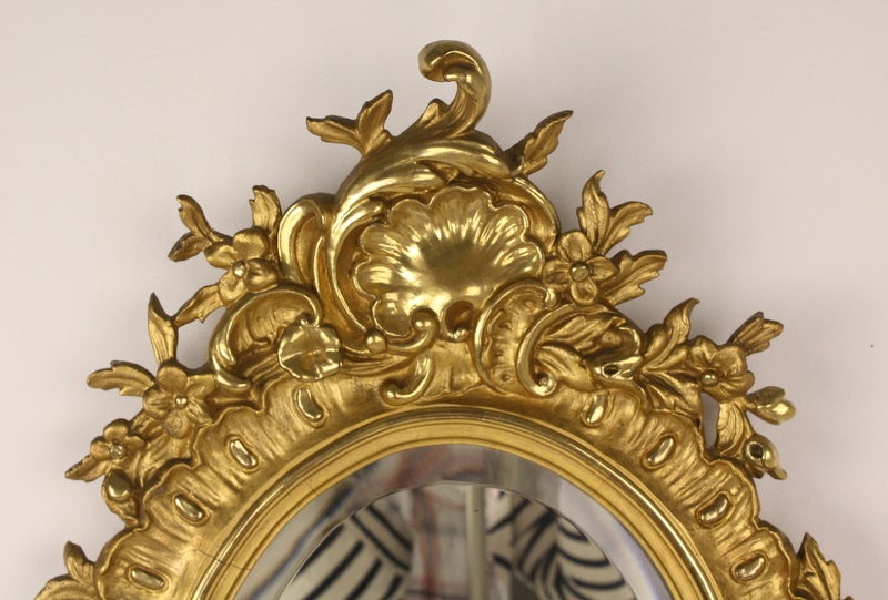 Beautiful shiny gilt, very charming.  Very pretty carving.  Some would put this over a rustic side cupboard, for a chic look! The mirror is well-beveled, good all-around size.