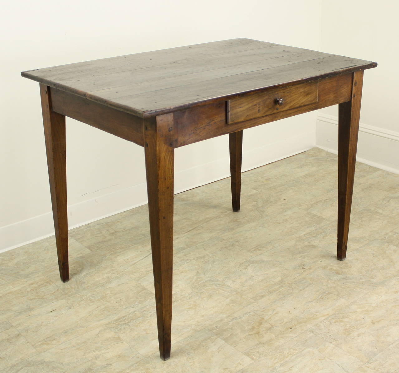 A fine example of an antique writing table, complete with warm color and nice patina.  The elegant tapered legs are nicely pegged at the apron, and the single drawer slides open easily.  Good apron height for knees at 251/2