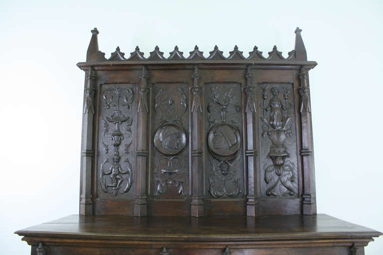 A very grand and impressive cabinet.  Seven feet tall to the top, seems perfect for a hunting lodge! The carvings are wonderful, and quite fun too. The color is  a rich dark oak, and there is metal trim, darkened over time. Old locks on the two