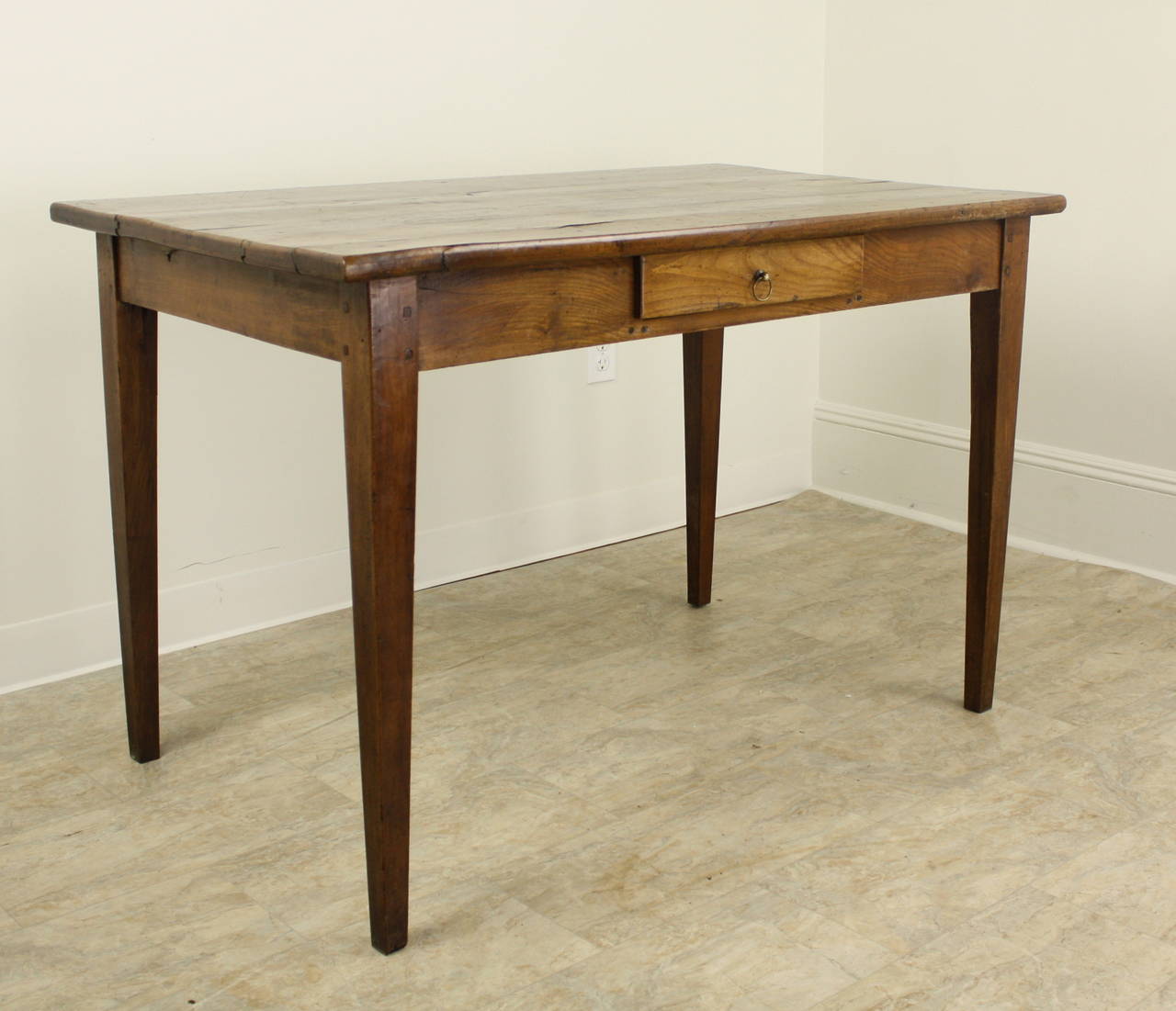 A nicely proportioned French writing table or desk, beautifully grained on top with a single drawer with original brass ring pull,  Elegant tapered legs are pegged at the apron, which at 25