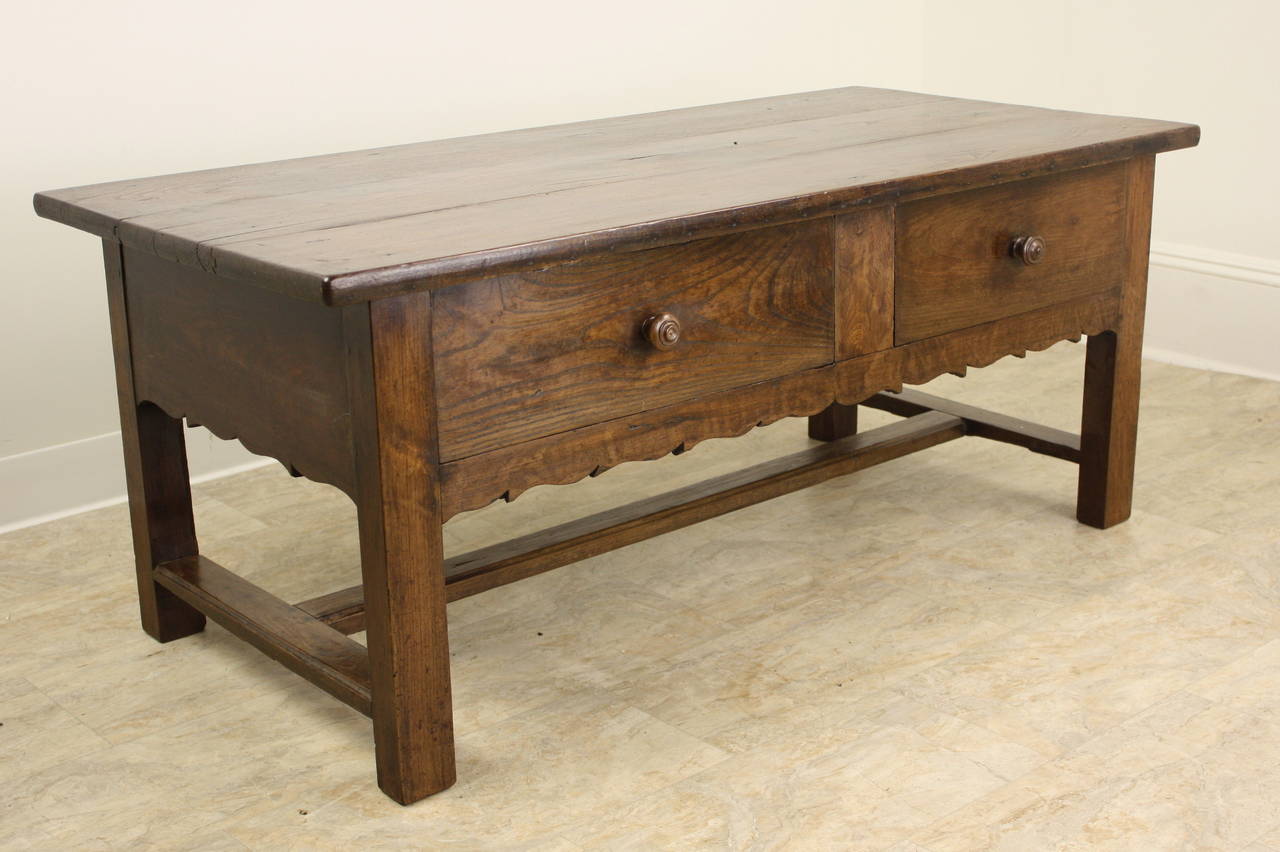 One of the most charming coffee tables we have had in our showroom! Dark rich color and patina and good grain on the top and front.  The carved apron, along with the asymmetrical deep drawers give this piece a wonderful country look.  The trestle