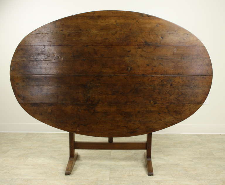 An extremely  good-looking oval dining table.  The French wine tasting table base, which swivels, is classic and very graceful.  Excellent storage when placed up against the wall as was typical in the vineyards, until it was wine-tasting time!  This