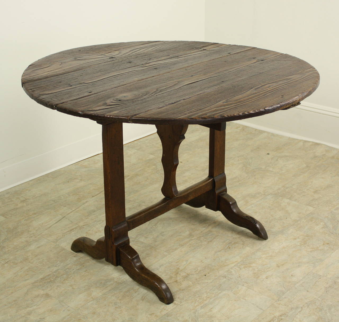 The pine graining on this very good vendange wine tasting table is quite wonderful.  The swivel table base is easy to use and is sturdy. The table can be stored upright if required, but would be a great center table or side table. Very nicely shaped