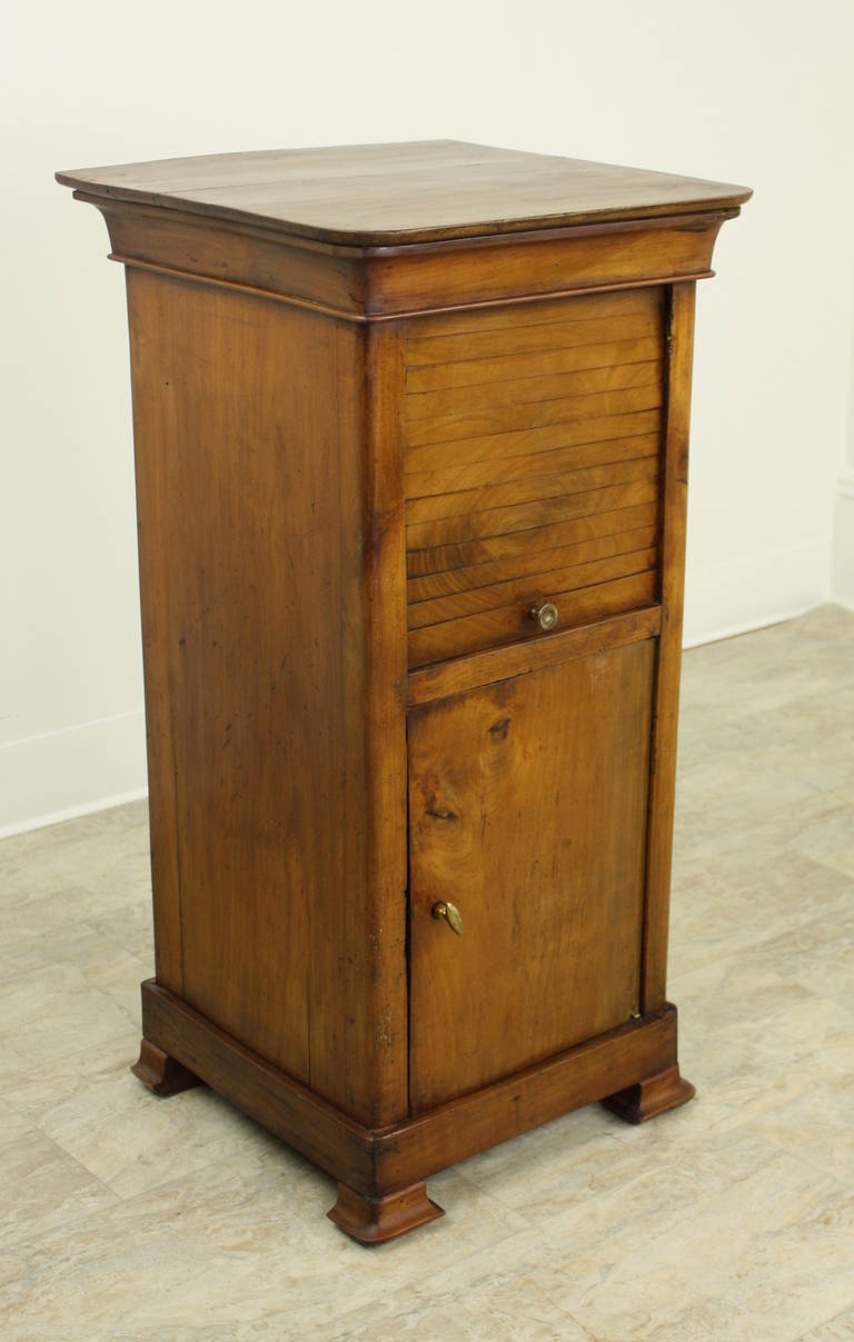 Very charming Louis Philippe nightstand, in a lovely color and patina.  Tambour fronted pieces are rare, and this one is particularly nice. Good height for a lamp, and a  narrow width so it will fit in a number of small spots. An excellent end