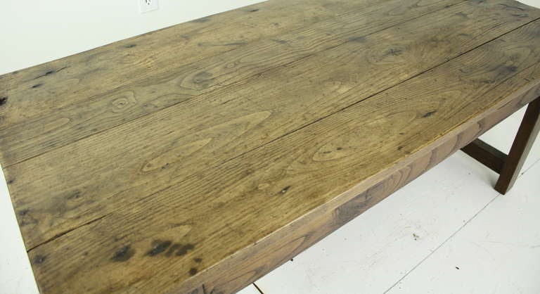 A lovely antique coffee table from France. Made of chestnut with a vivid grain and a beautiful warm patina. Note the stretcher and slightly rounded corners to the top. Nice farm table style legs. One drawer on the end..