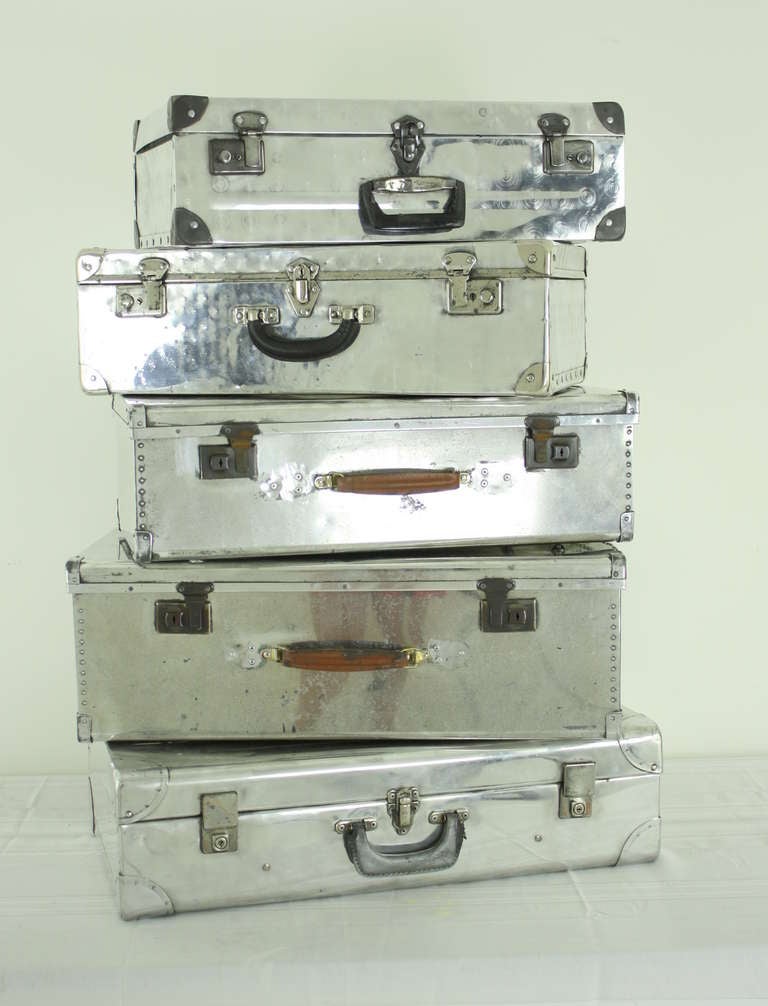 A shiny stack!  Piled up on top of your favorite armoire.  Rearrange them as you wish.  The aluminum suitcase came info favor after WWII as people were beginning to travel more. The aluminum material was plentiful after the war, and had the