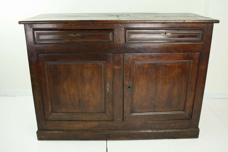 Large antique country sideboard from France. The deep chestnut is rich in warmth and patina. Original keys and escutcheons for both drawers and the cabinet below. There is a shelf inside for ample storage. 