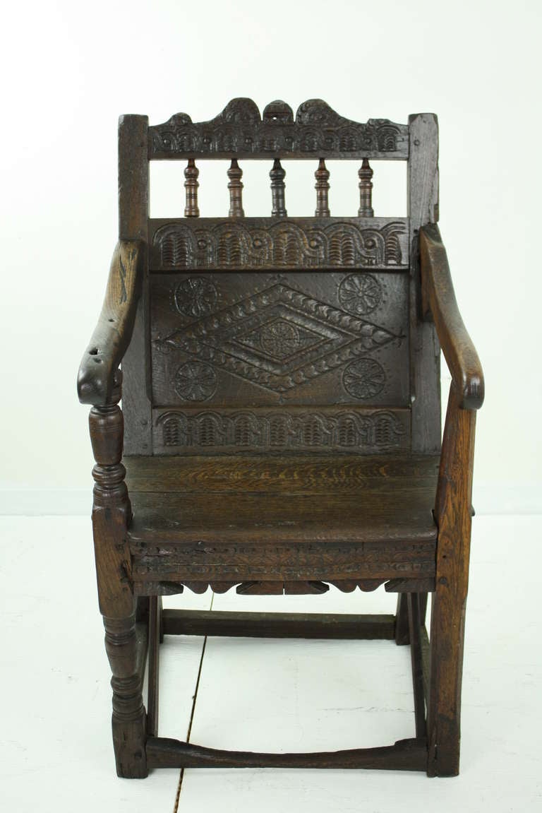 A true well-used early oak Wainscot chair the real thing! The chair has undergone repairs through the ages, most noticeably the replacement of the entire front right leg, where a creative craftsman has made a chamfer on the inside edge. The 300+