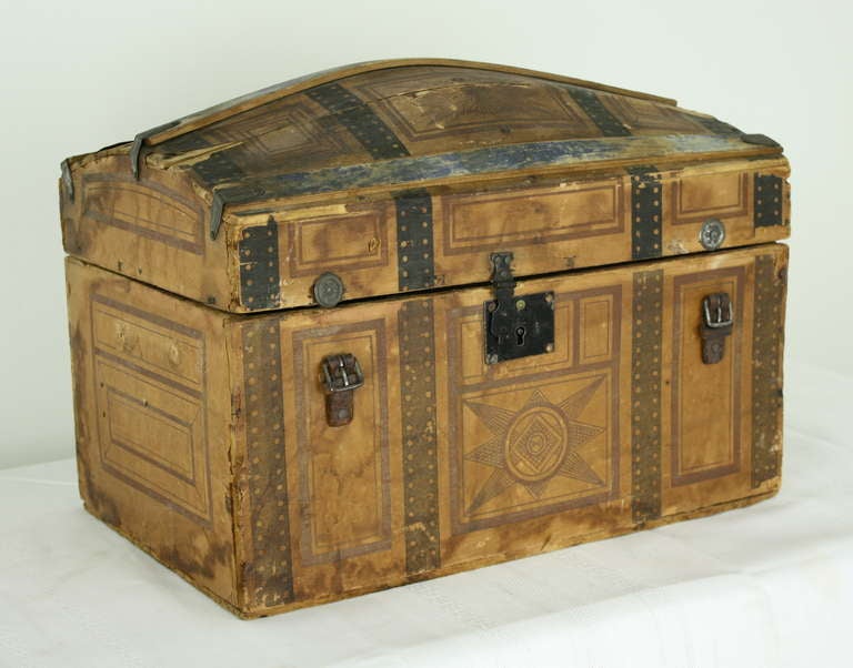 A charming, quite distressed, dome-topped box, with a fitted tray. The exterior of the box is covered in paper, painted to fit on the box to show faux leather straps and interesting design work. We added new small hinges to the back of the box,