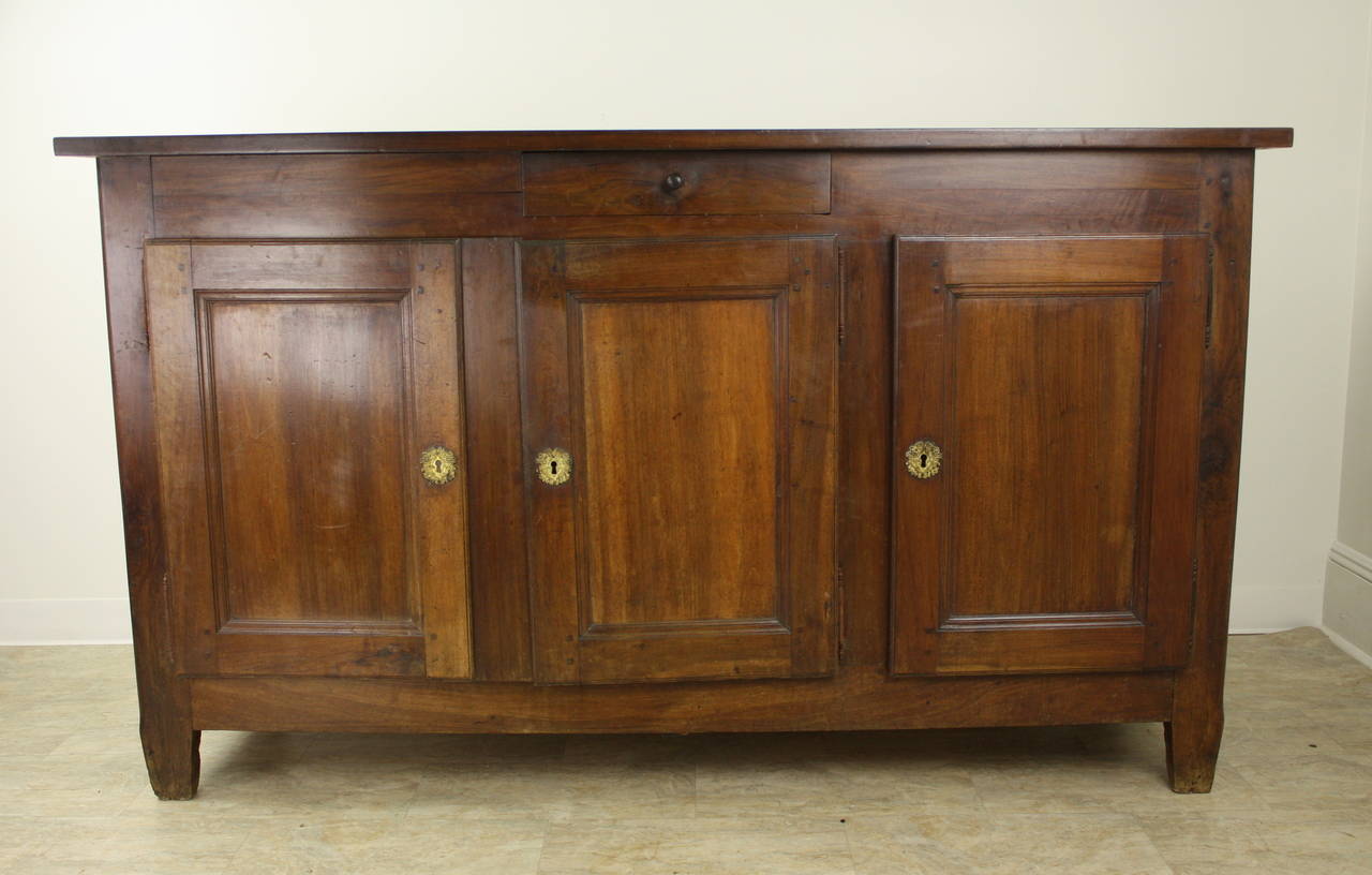 A striking dark cherry three door enfilade from France, circa 1840. Beautiful lustrous cherrywood and an imposing silhouette. The two doors on the left open to a wide, deep cupboard with a single shelf. The door on the right also opens to a single