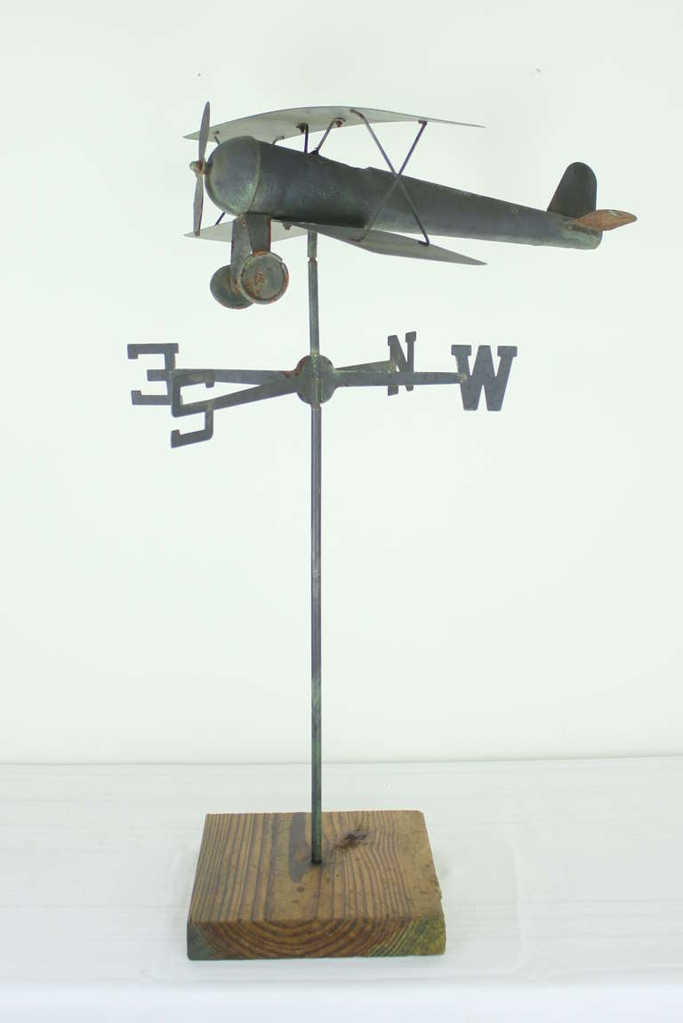 Charming and fun.  Seems to be a miniature weathervane.  Recently put onto the wood stand, but the plane itself is old and has had some use, perhaps as a toy.  Looks great on a coffee table. Purchased for its decorative value.