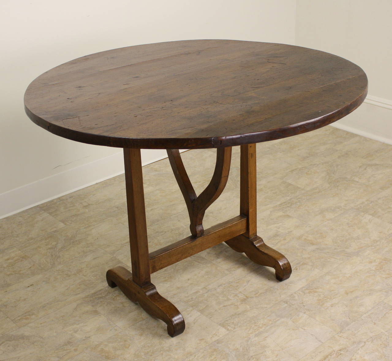 This is a great-looking French wine tasting table. Beautiful color and patina, and a nice thick top.  Because there is no apron, the round breakfast dining table is quite comfortable for knees. Easy for six to sit, with smaller-sized chairs. Strong