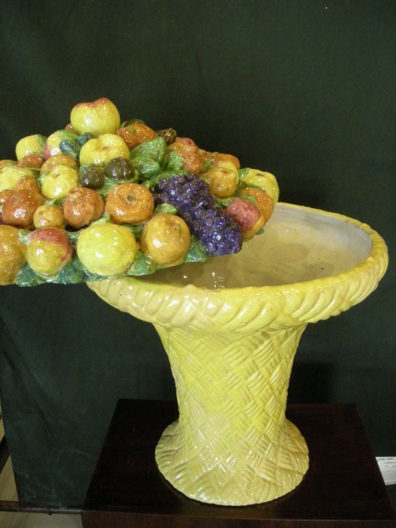 A unique and striking piece of Italian Majolica pottery. Basket weave base with a multicolored top featuring a variety of fruits.