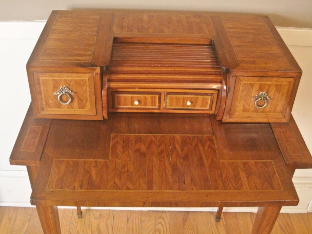 A wonderful small ladies desk, with chevron pattern parquetry inlay. The front with pull out writing surface; when pulled out it raises tambour to reveal two small drawers. Late 19th Century.