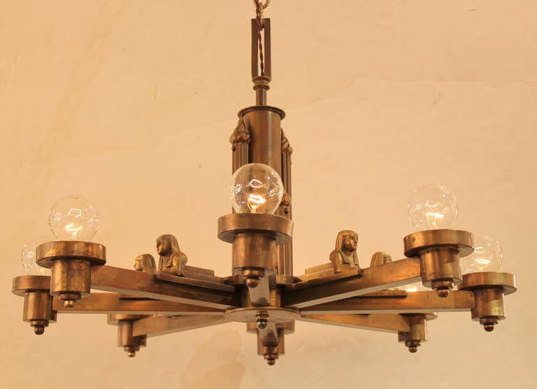 Egyptian Revival Brass Chandelier.  Sphinx Motif.  Newly rewired.  8 Arms Probably American.   Fluted Center Column with Flames.