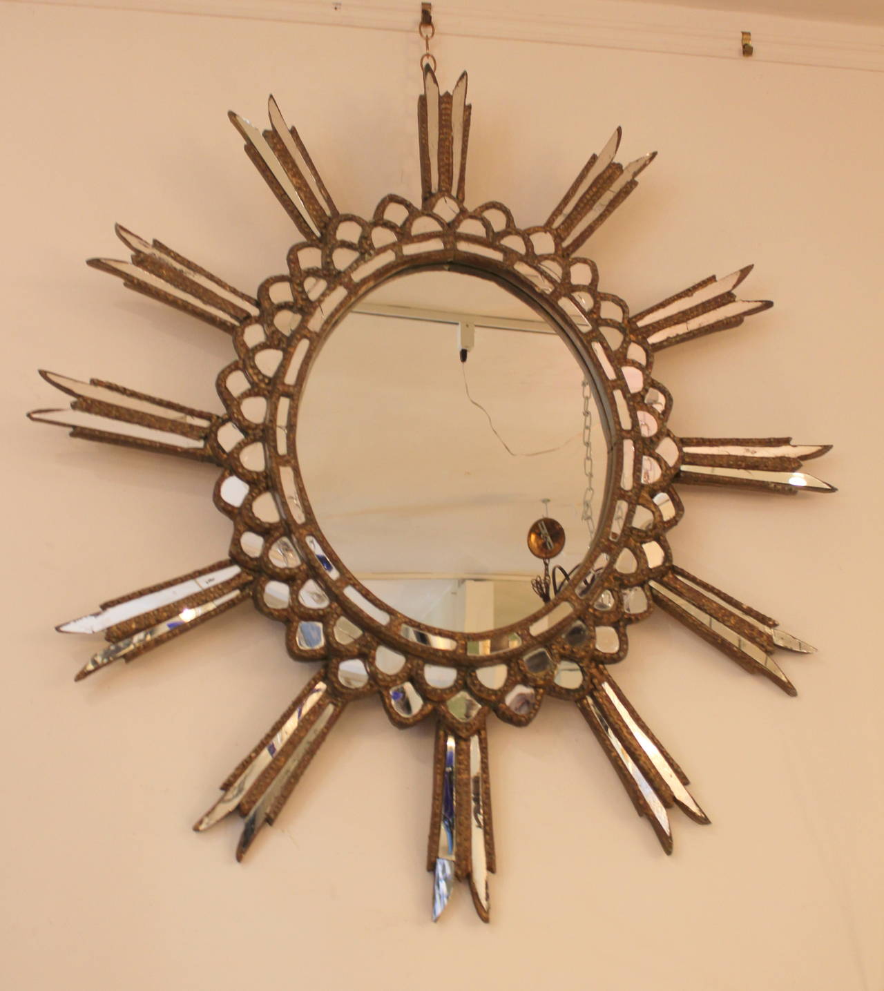 1940s Argentine starburst mirror. Original gilt finish and mirror.
Some minor broken mirror pieces.