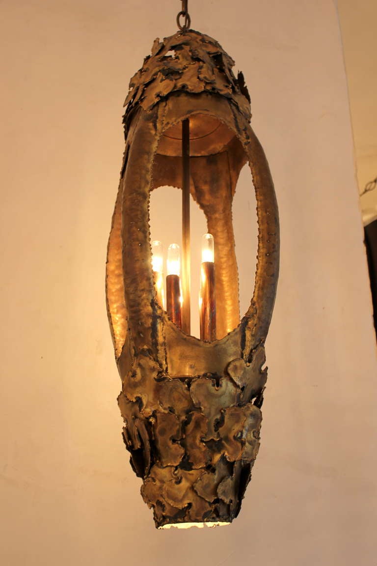 Tom Greene Brutal Pendant  Chandelier. Pendant has 5 lights with brass candle covers and spot light below.