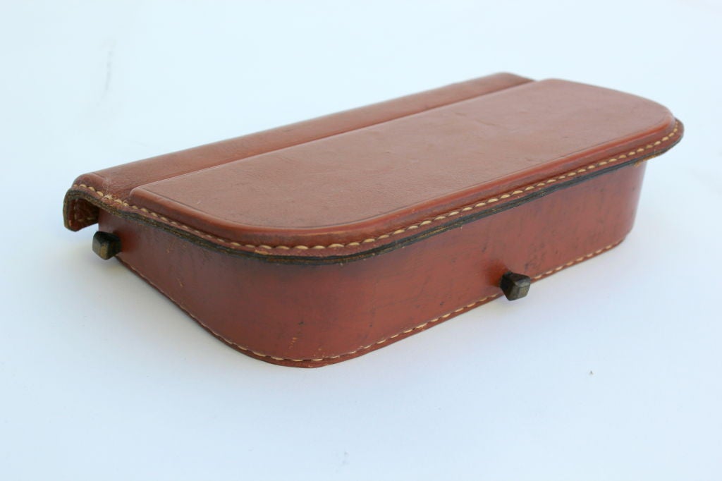 Saddle stitched leather box with brass details. Mahogany interior.