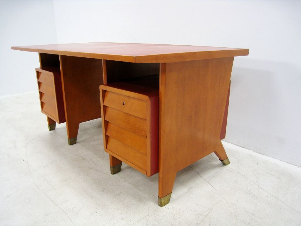 Rare Ponti desk designed for a site specific installation for the city offices of Forli, Italy. Red linoleum wraps the double pedestal and the top surface of the desk. Brass sabots.