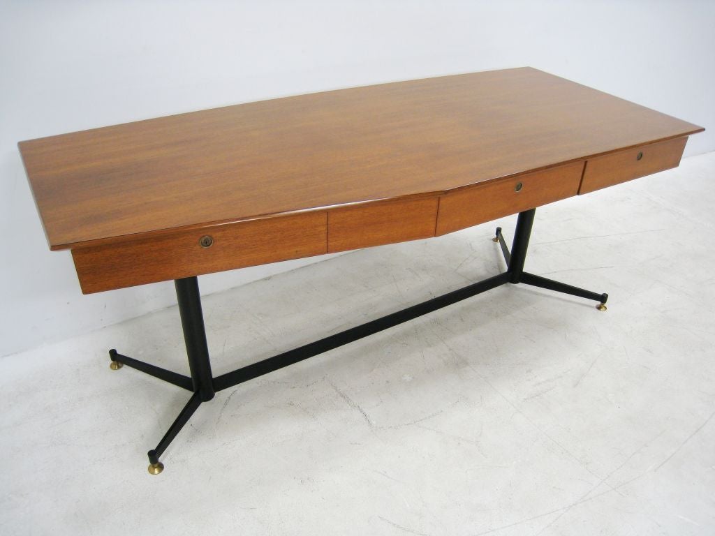 Osvaldo Borsani walnut and metal desk with three locking drawers. Unusual cut design to the top of the desk echoed in the base.