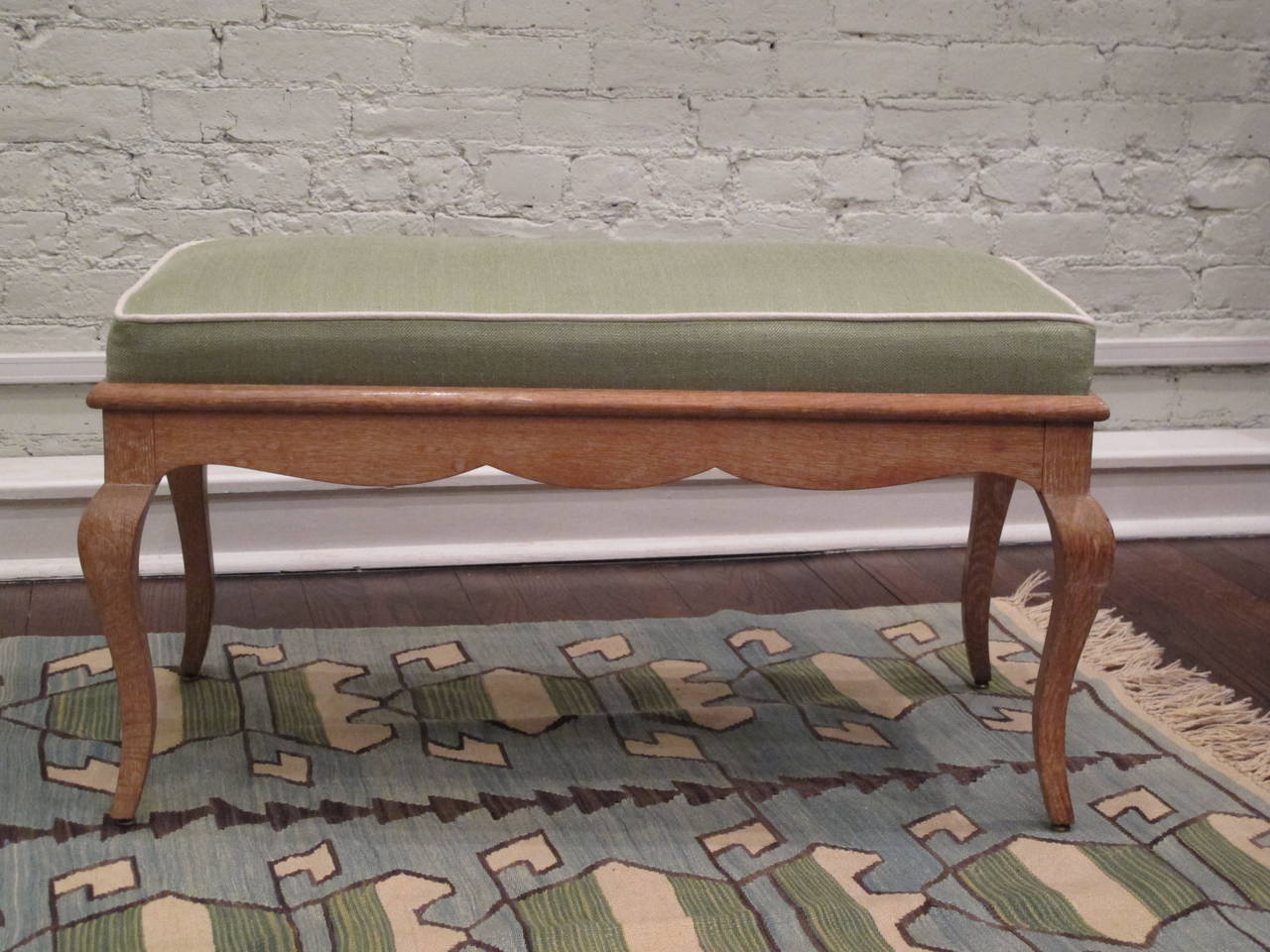 Cerused oak bench with box cushion, newly recovered in green linen with ivory linen piping.