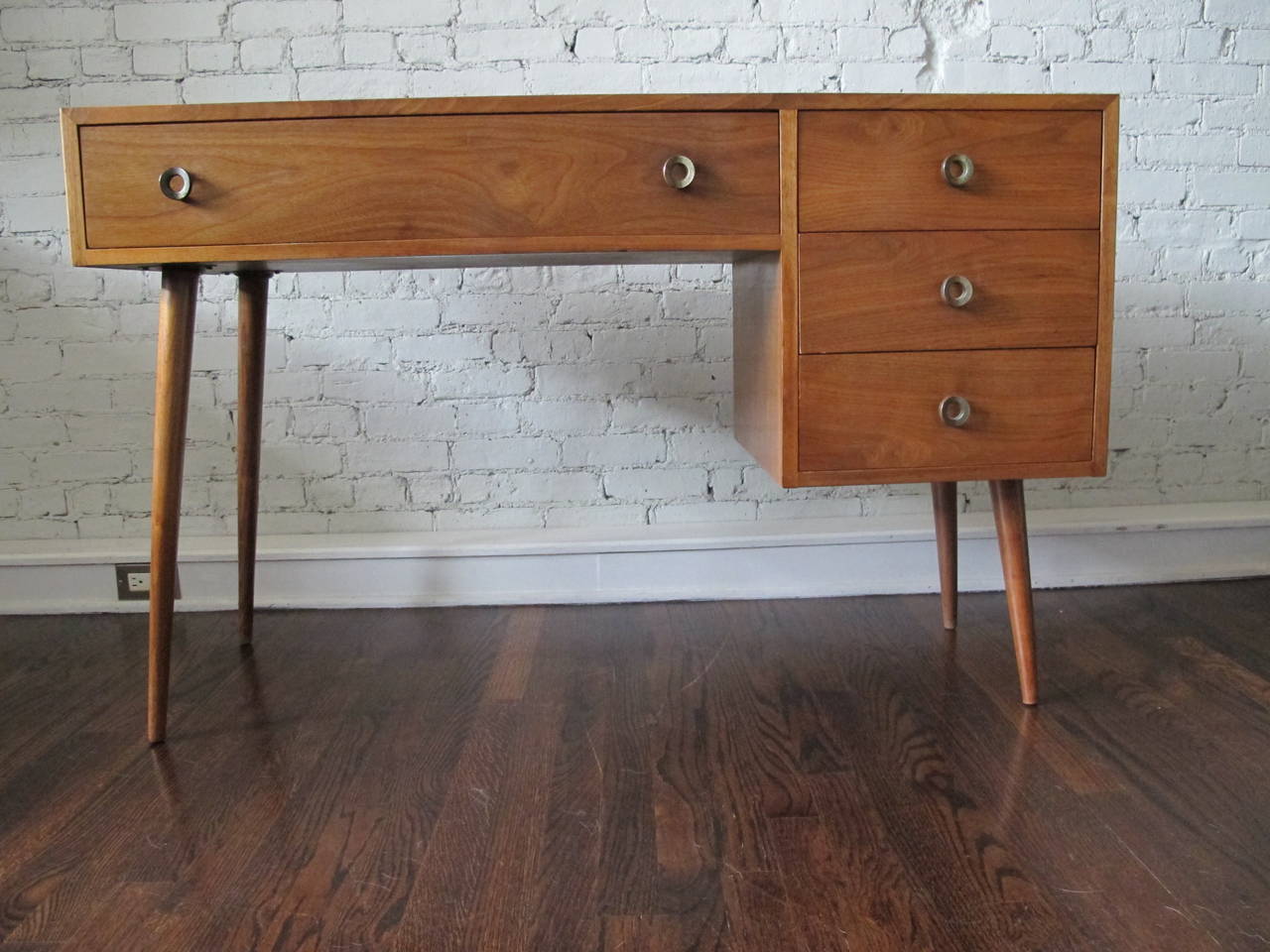 Small writing desk or vanity in American walnut, designed by Stanley Young for Glenn of California. Features four drawers. Great original condition with some light scratches from use. Knee hole is 23