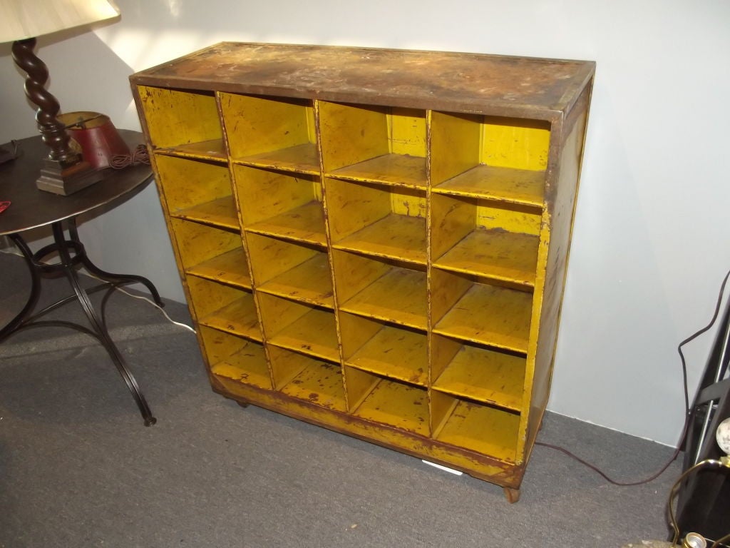 A yellow painted industrial rack from a shoe factory used to move shoes from station to station in the factory as the shoes were made.  On original casters.