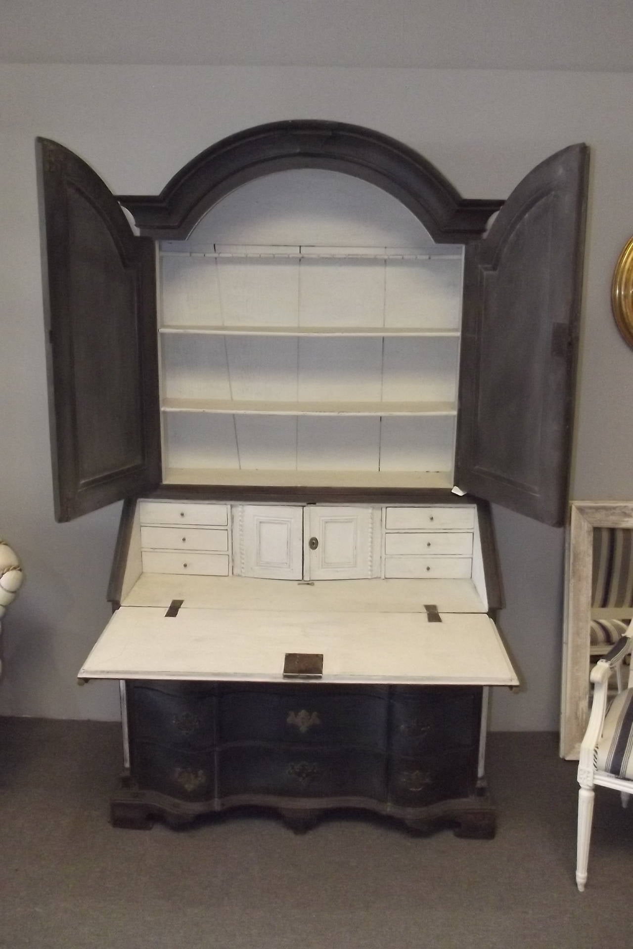 A Swedish Rococo period secretary desk dating from the middle of the 18th century with with exceptional detailing throughout including a detailed interior, serpentine drawer case, bracket feet quarter columns with brass capitals and bases, and bold