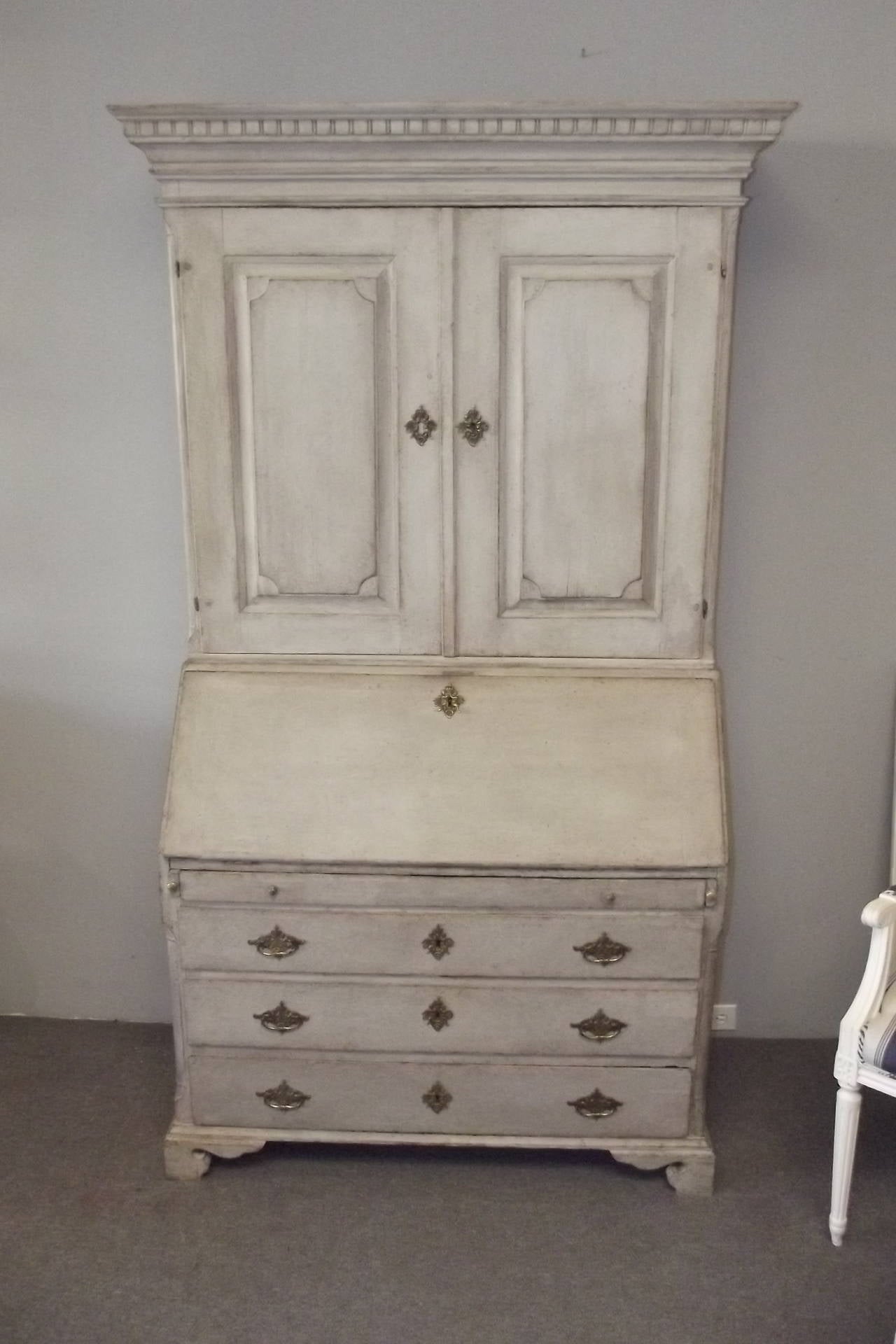 A Swedish secretary desk dating from the end of the Gustavian period in old but not original white painted surface. It is in excellent overall condition with wonderful cherub brasses and a detailed interior. There is overall beautiful detailing