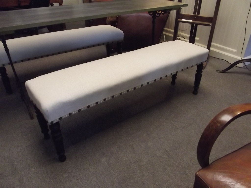 A Napoleon III bistro bench newly upholstered in Boyd's Natural Linen fabric and trimmed in gimp and brass ornamental tacks.