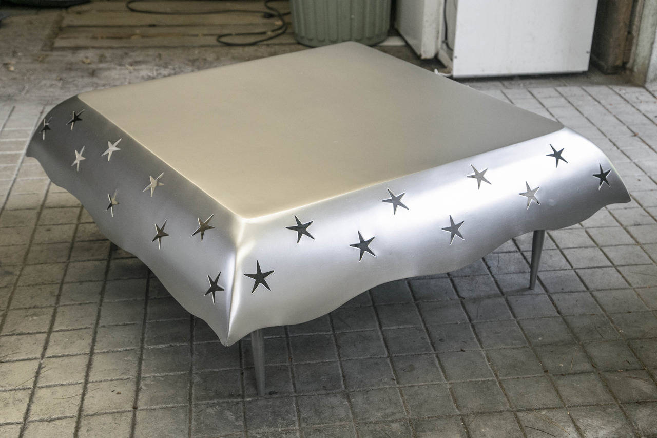 Table basse en aluminium avec étoile découpée par la designer française Sylvia Corrette. La surface de la table est de 31