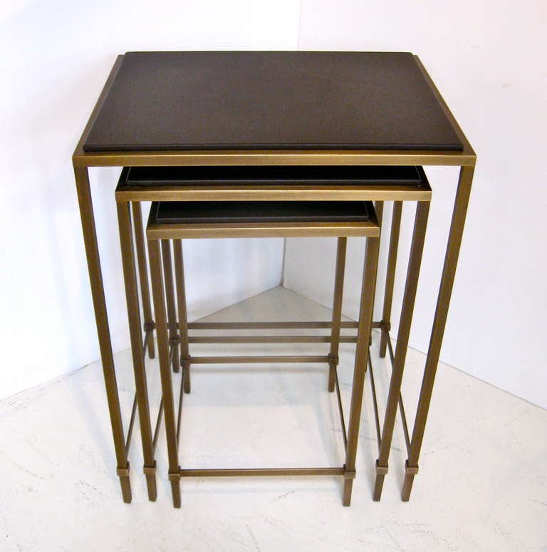 Set of three leather topped nesting tables with metal banding and legs.