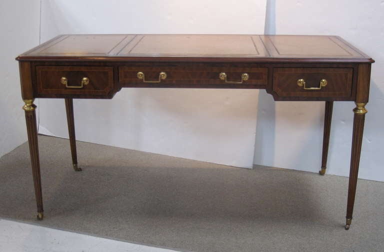 Beautiful solid wood desk with tooled leather top by Maitland - Smith.  This desk features pull out extension leaves on either side, each measuring 11 inches.  There are three drawers on each side, only the front ones open. Small casters on fluted