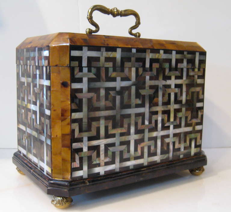 This lidded box by Maitland -Smith is comprised of penshell and mother-of-pearl inlaid in a fretwork pattern.  Cast brass mounts and handle with amazing detail complete the piece.