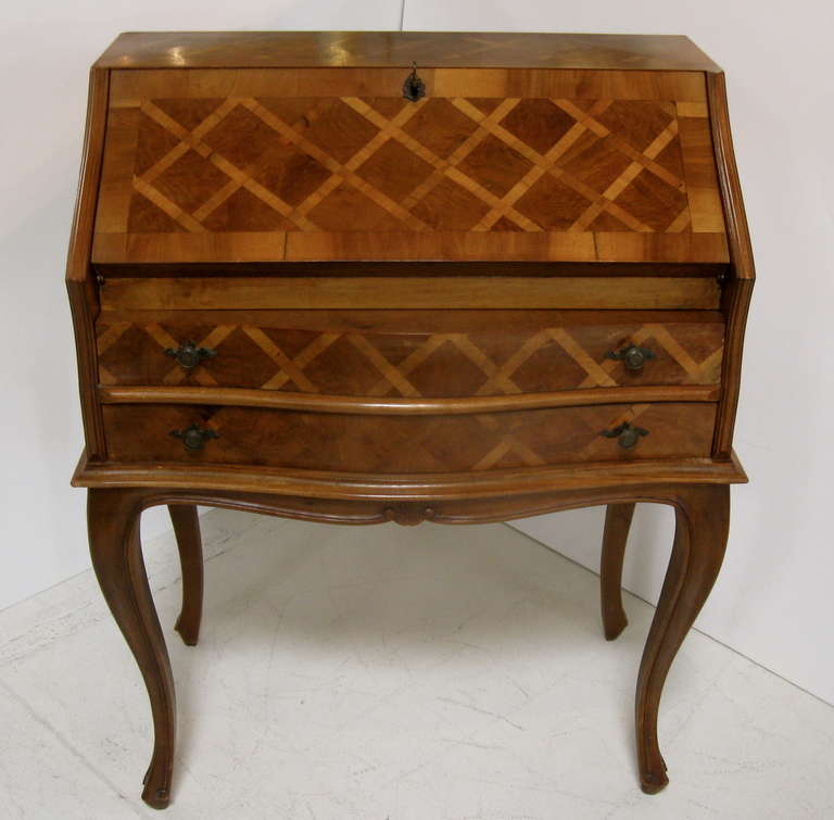 Lovely and graceful secretary / desk from italy.  There is a pull down front that opens to a writing surface, with several drawers.  There is also a working key that locks and opens desk.  Detailed parquetry design in a diamond pattern and cabriole