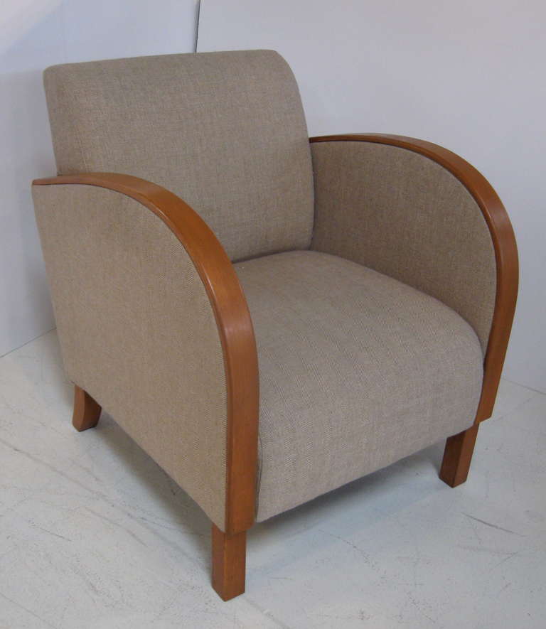 Great pair of art deco style armchairs, with curved bands of wood framing the curved arms.  Recently upholstered in beige fabric woven with a slight herringbone design, as seen in image 8.