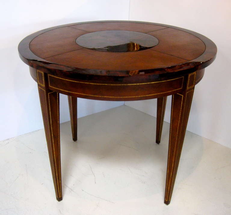 Round, leather clad center or side table, with gold tooling on leather. Exquisite rosewood edge and center parquetry  medallion.  Attributed to Maitland Smith.