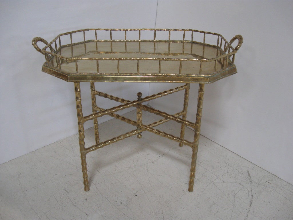 Bamboo inspired tray table in solid brass.  Folding base of table has a bamboo inspired design.  Removable brass tray has a 