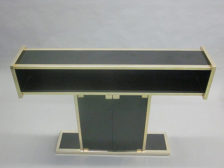 A Sober, Elegant French Mid-Century Modern Console in the style of Willy Rizzo that can function as a bar, sideboard, buffet, etagere, serving table, sofa table or small cupboard. The piece is composed of Chromed metal and black opaline glass and