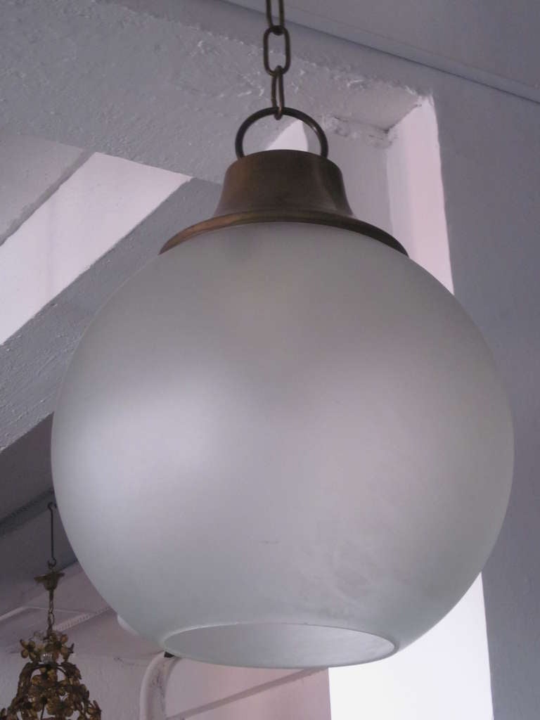 Elegant, Sober Italian Mid-Century Modern neoclassical frosted glass ball pendant / chandelier/ lantern by Italian Master, Luigi Caccia Dominioni. It is composed of a large mold blown Murano / Venetian glass shade and secured by a designed brass
