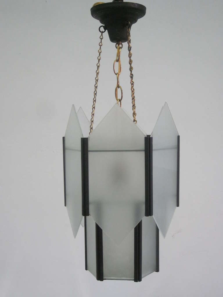 Elegant, sober and timeless hexagonal form chandelier or pendant with modern and Art Deco influences with a bronzed metal frame and frosted glass panels.