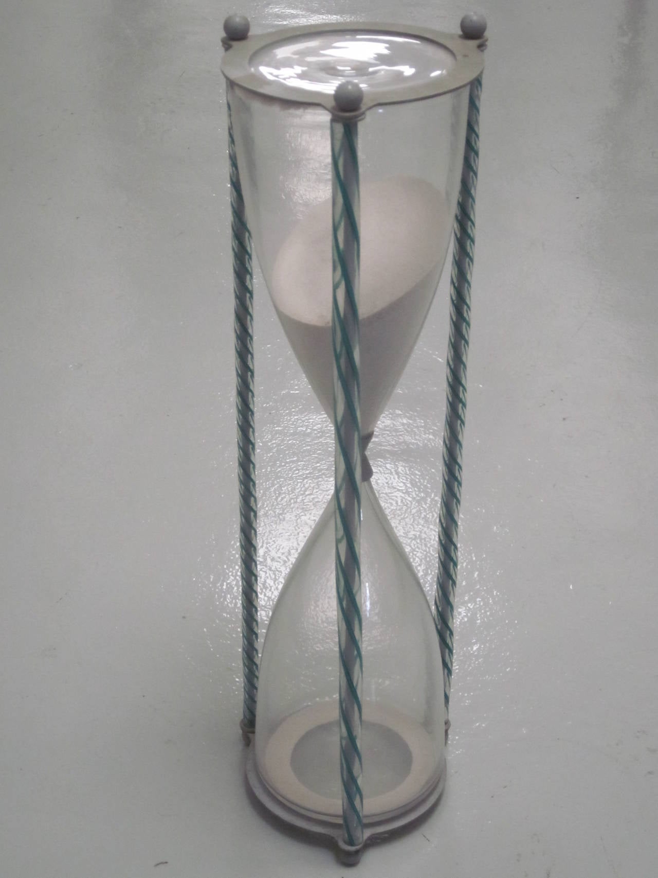 A large, rare Italian Mid-Century handblown hourglass designed by Paolo Venini, circa 1955 with three handblown glass zanfirico twists securing the hour glass to the metal frame. This wonderful Murano/Venetian glass object represents the elegant,