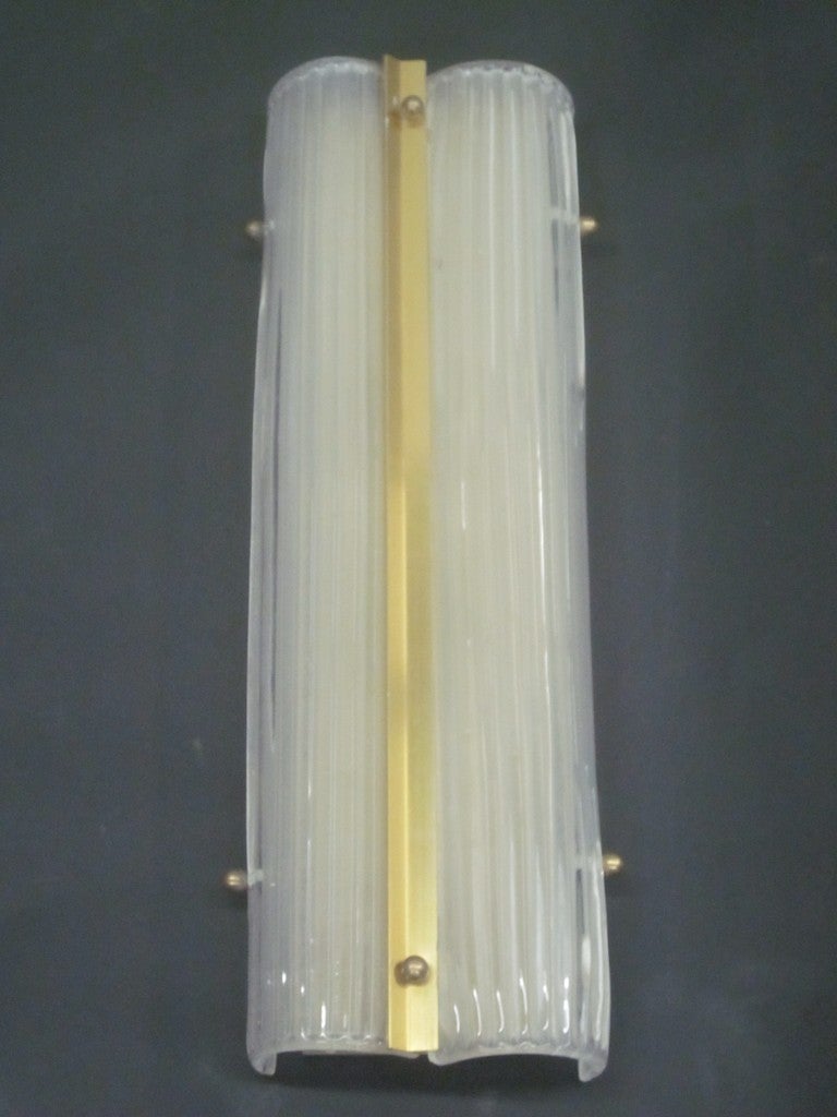 Elegant pair of large Italian Mid-Century handblown Murano glass wall lights in a sober, modern style. The glass is thick, opaque and ribbed. 

Can be oriented vertically or horizontally on the wall or used as flush mount fixtures on the ceiling.