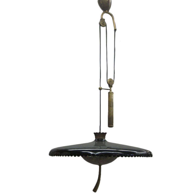 An elegant Italian Mid-Century Modern chandelier/fixture by Pietro Chiesa to give reflected light to an area by means of a solid brass counter-balance mechanism that raises and lowers the enameled metal and brass shade. Light sockets are imbedded