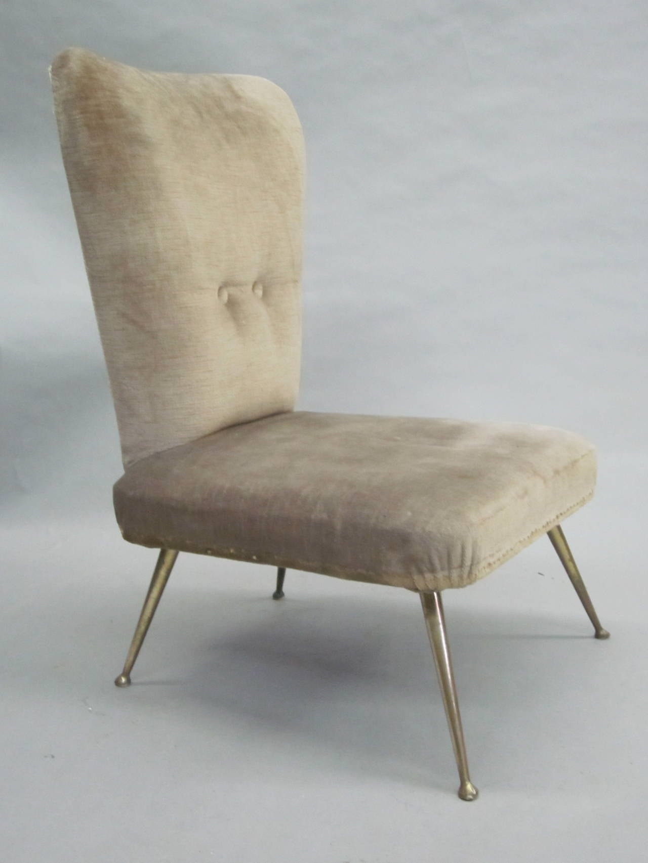 Elegant pair of midcentury Italian design, small lounge or slipper chairs attributed to Marco Zanuso. The chairs feature delicately tapered backs and front and rear sabered legs in solid brass creating pure. Sober lines and forms.
Pieces are covered